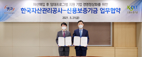 5월21일 캠코양재타워(서울 강남구 소재)에서 개최된 자산 매입 후 임대프로그램(S&LB) 지원 기업 경영정상화를 위한 업무협약」에서 김귀수 캠코 기업지원본부장(사진 왼쪽), 신용보증기금 최창석 이사(사진 오른쪽)가 기념촬영을 하고 있다. (캠코 제공)